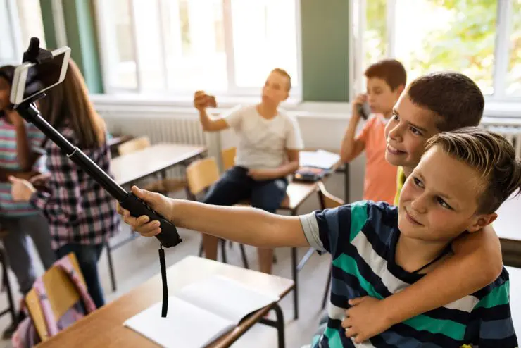 elever i folkeskole med mobiltelefoner og selfie-stang