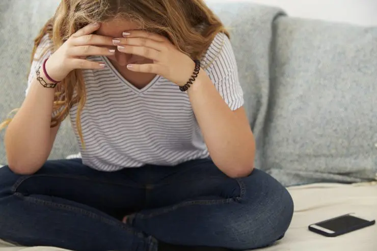 deprimeret teenagepige der er trist på grund af sin mobiltelefon