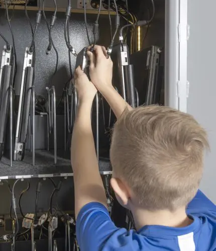dreng på en folkeskole foran et sikringsskab til computere
